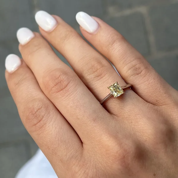 Radiant cut yellow diamond ring worn on the hand in 18k white and yellow gold with a 1.01 ct GIA-certified natural diamond.