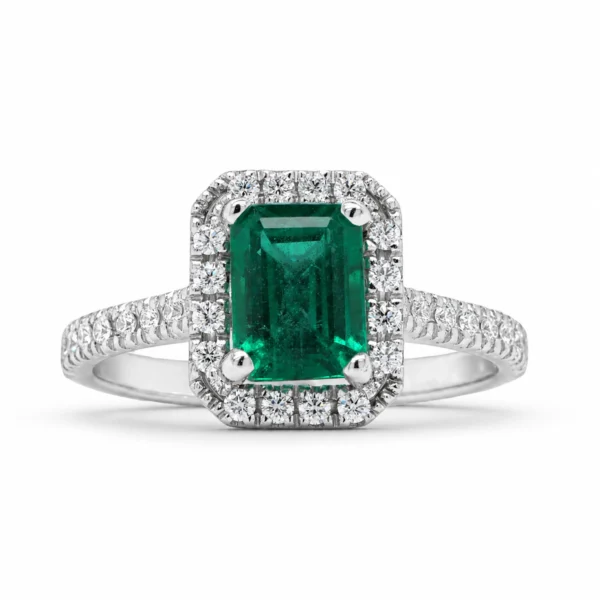 Emerald cut emerald halo ring in 18k white gold with a 1.09 ct natural emerald and 0.25 ct D–F VS natural diamonds, front view.