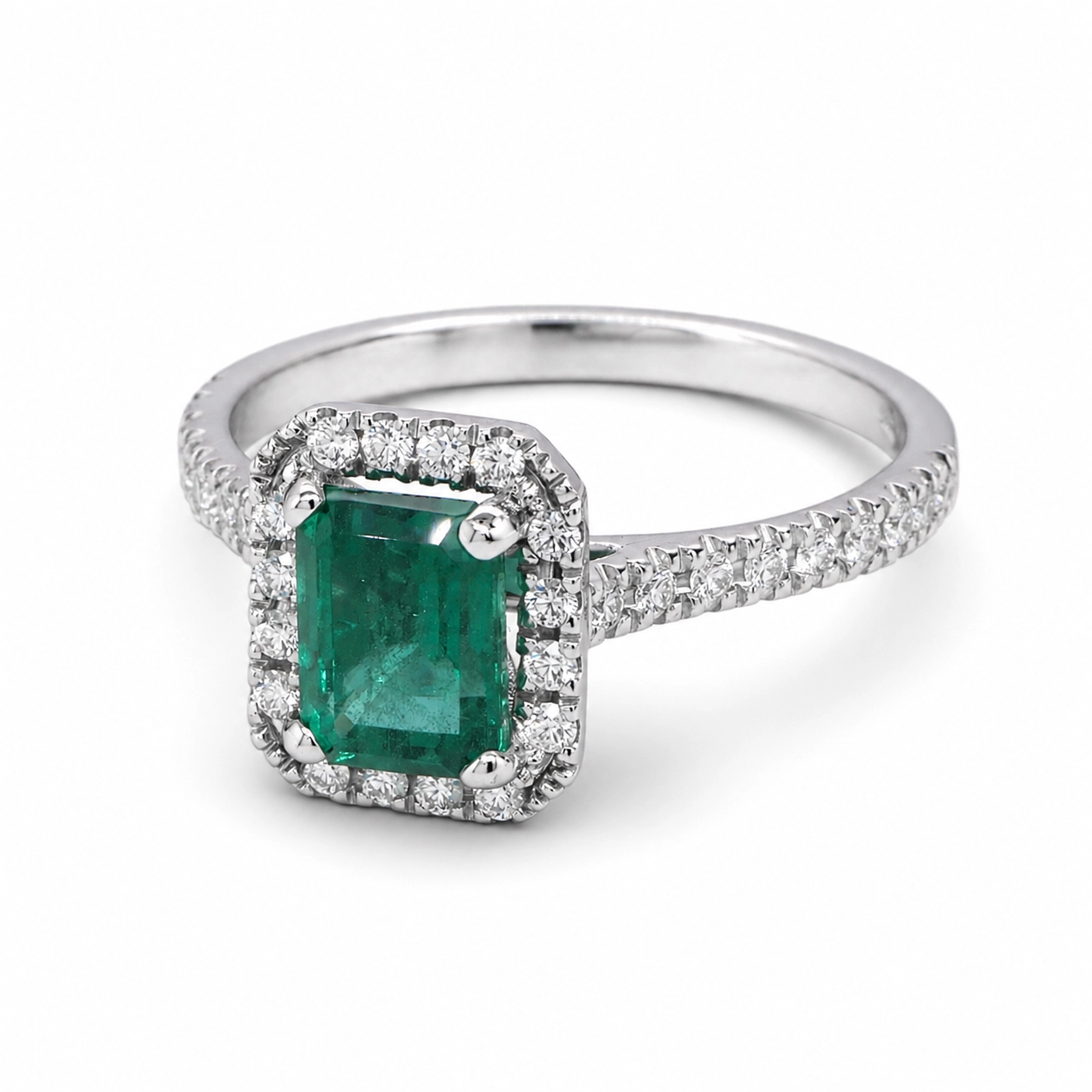 Bague Halo Émeraude Taille Émeraude En Or Blanc 18 Carats 5 - Orogem Jewelers Vue En Angle D’une Bague Halo Émeraude Taille Émeraude En Or Blanc 18 Carats Avec Émeraude Verte Centrale Et Halo De Diamants.