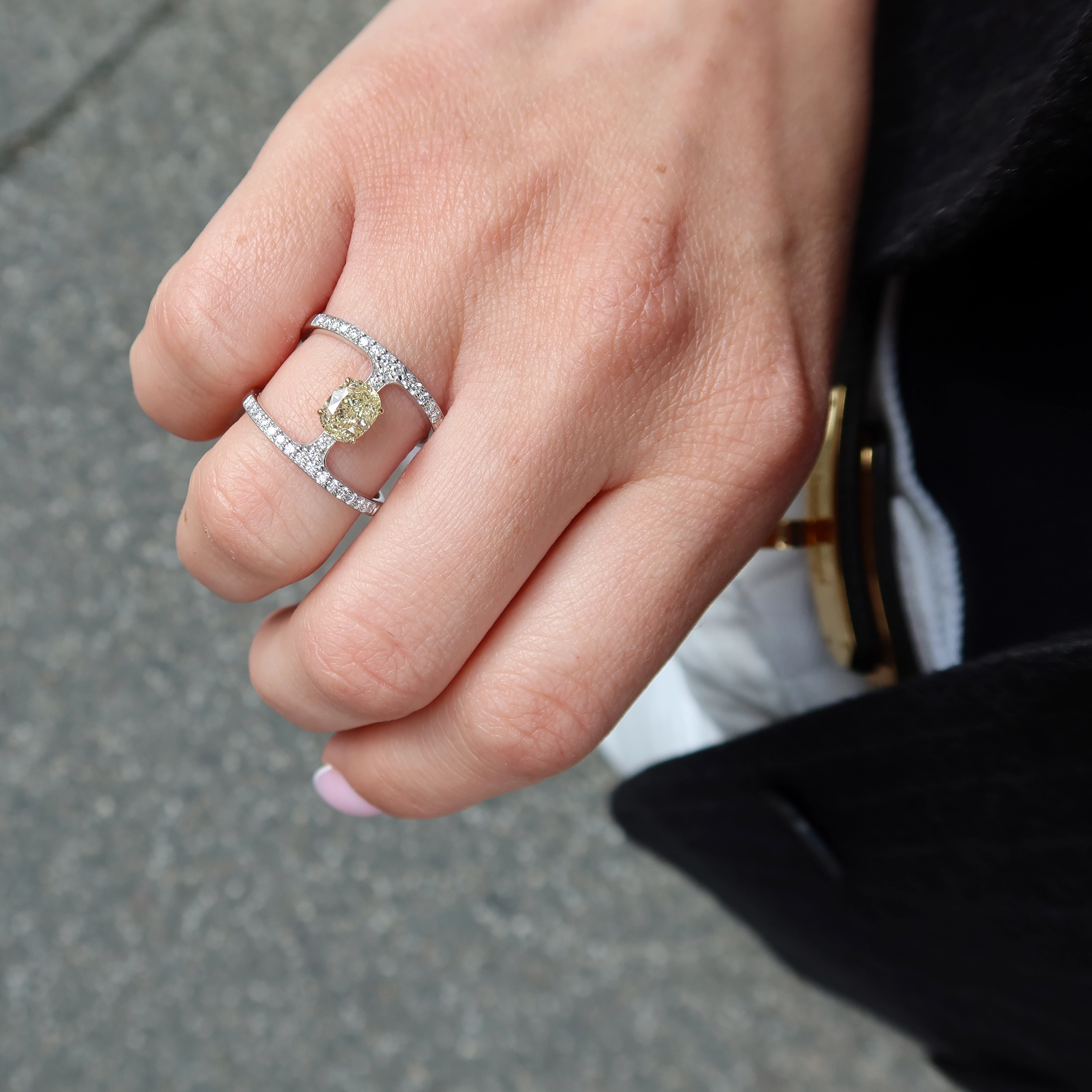 Ovale Gele Diamanten Ring In 18K Witgoud Met Dubbele Pavé Band 4 - Orogem Jewelers Handfoto Van Een Ovale Gele Diamanten Ring In 18K Wit- En Geelgoud Met D-F Vs Pavé Diamanten En Geelgouden Griffen.