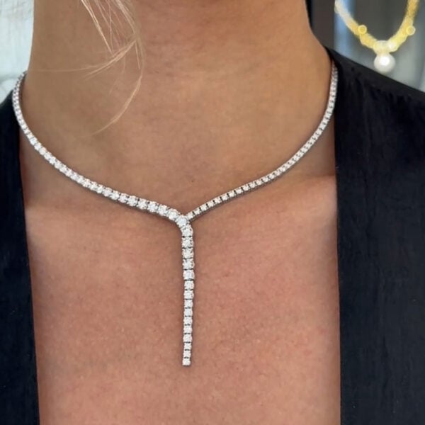 this 18K white gold diamond drop necklace features a harmonious cascade of 10.81 carats of brilliant round-cut diamonds