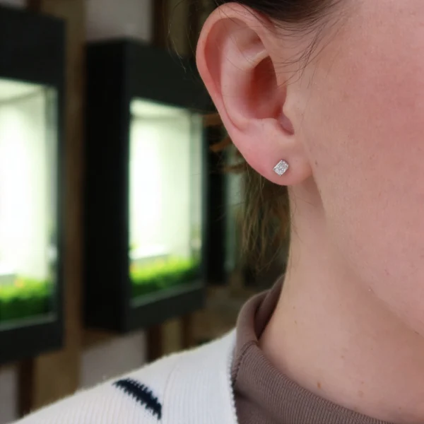 Boucles diamants radiant GIA portées à l’oreille, serties de diamants naturels de 0,62 ct total en or blanc 18 carats.