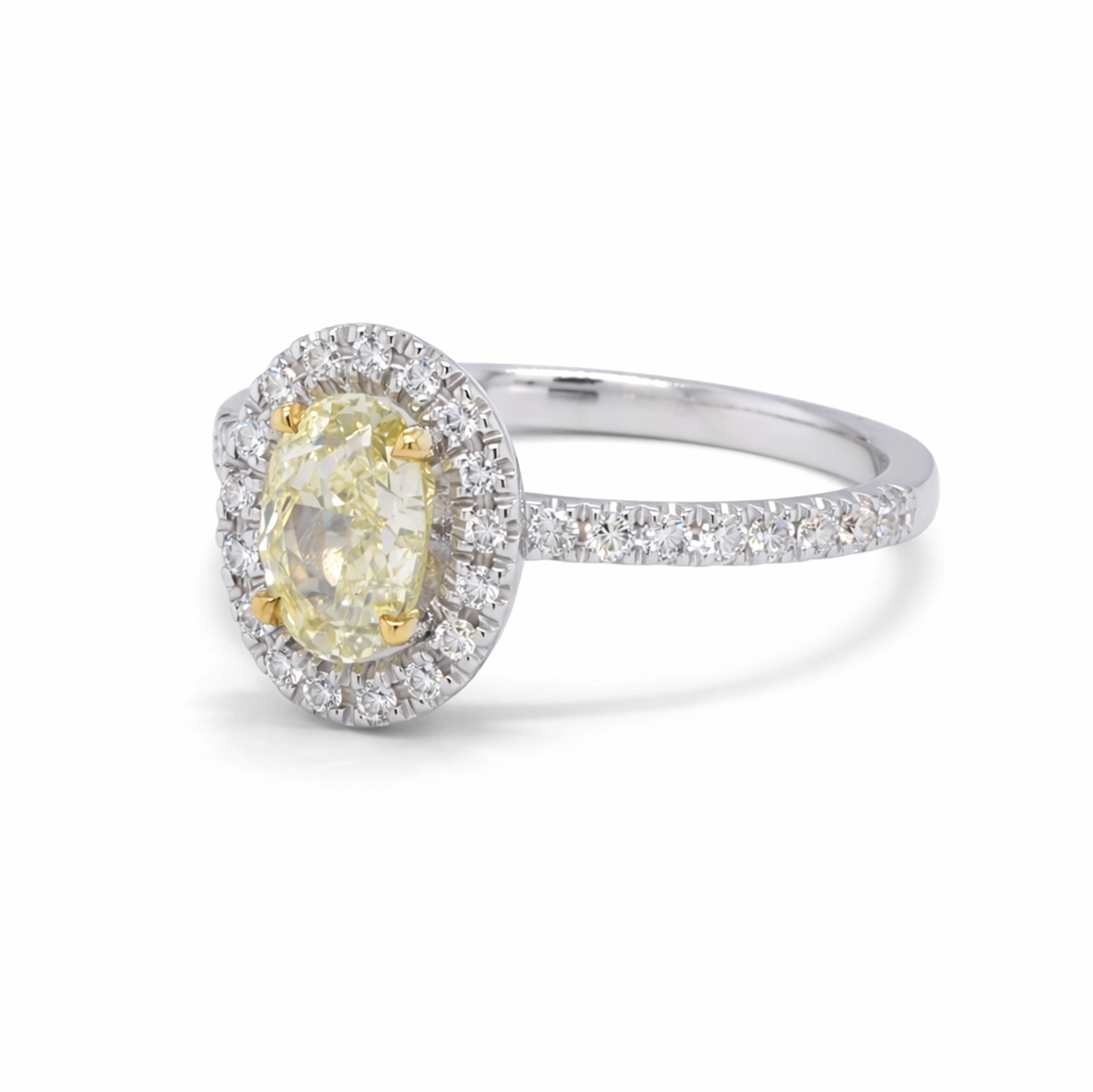 Bague Halo Diamant Jaune Ovale En Or Blanc 18 Carats Certifiée Gia 5 - Orogem Jewelers Vue De Trois Quarts D’une Bague Halo Diamant Jaune Ovale En Or Blanc 18 Carats Avec Diamant Central Fancy Light Yellow Certifié Gia.