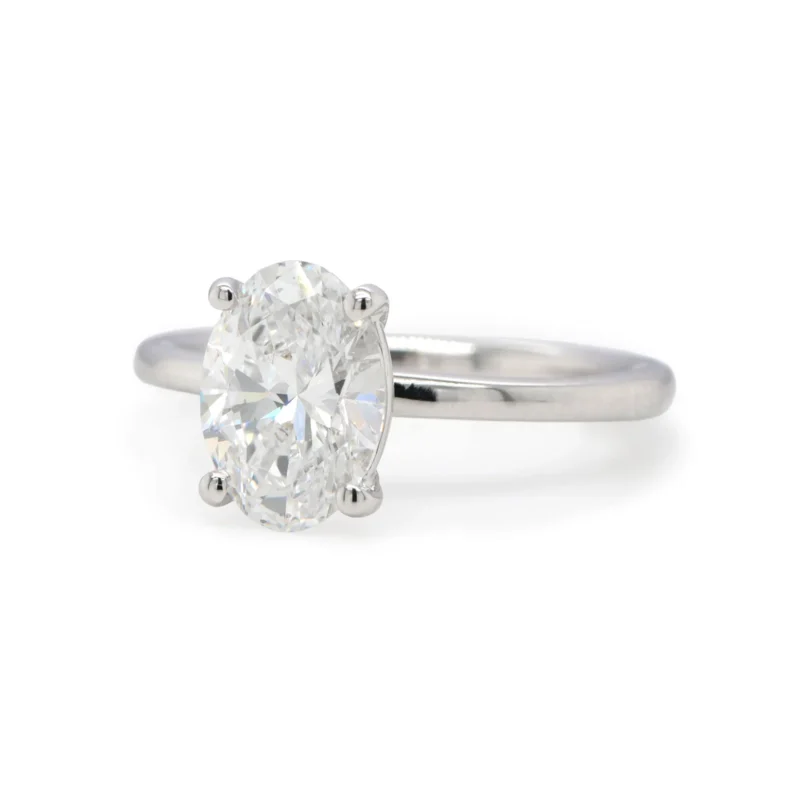 Angled Side View Of A 1.51 Carat Oval Cut Diamond Solitaire Ring In 18K White Gold Showcasing Its Four-Prong Setting.