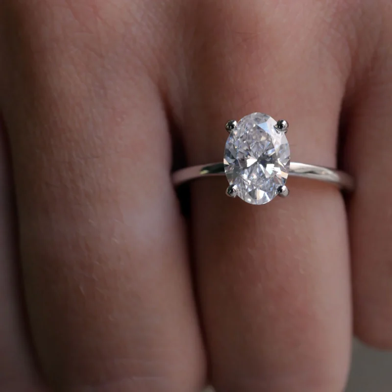 Close-Up Of A 1.51 Carat Oval Cut Diamond Solitaire Ring In 18K White Gold, Worn On The Ring Finger.