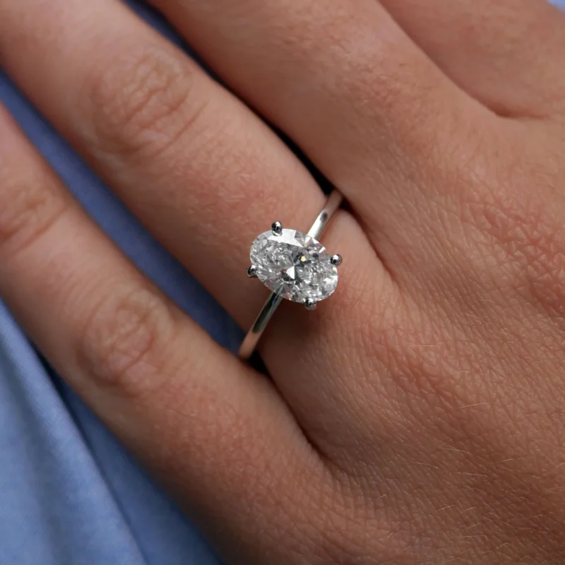 1.51 Carat Oval Cut Diamond Engagement Ring In 18K White Gold Shown On Hand, Highlighting Its Brilliance And Elegance.