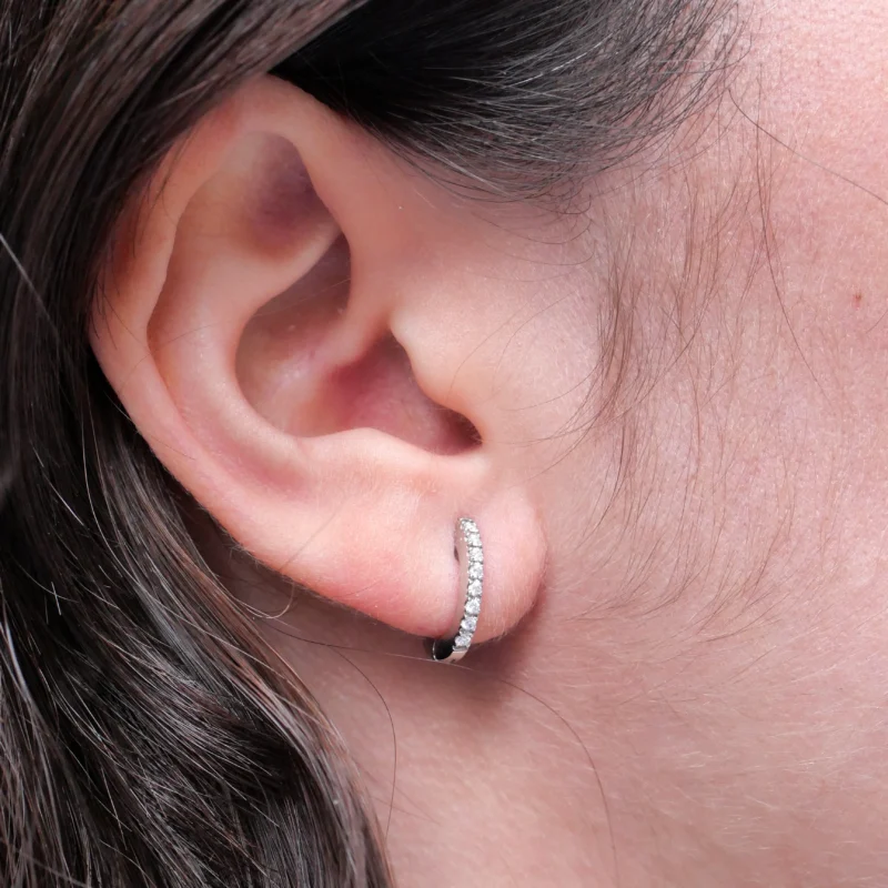 Petite Hoop Earrings In 18K White Gold Featuring A Row Of Brilliant-Cut Diamonds, Shown From Front And Side Angles.