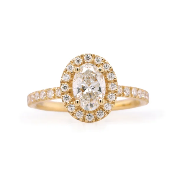 Halo ring in 18K geelgoud met ovale 0.71 karaat F VS2 GIA-gecertificeerde diamant en 0.27 karaat diamanten op halo en band, schuine aanzicht.