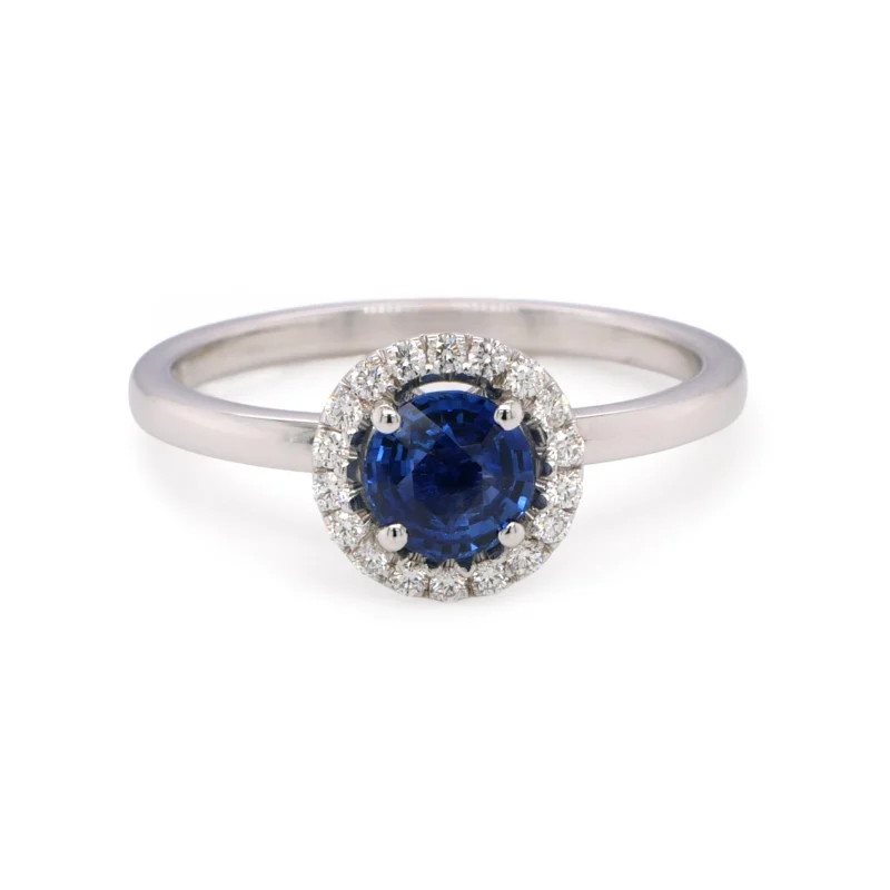 Close-Up Of Round Natural Sapphire Halo Ring With 0.10 Ct D–F Vs Diamonds In 18K White Gold.
