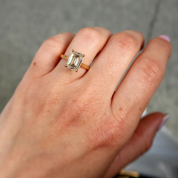 3.01 carat emerald cut light yellow diamond solitaire ring in 18K yellow gold, featuring a U–V color VVS2 clarity natural diamond with elegant step-cut facets