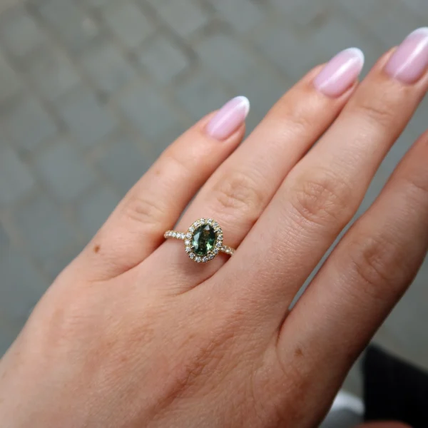 Anello halo in oro giallo 18K con zaffiro verde ovale naturale circondato da diamanti taglio brillante e gambo delicato con pavé di diamanti