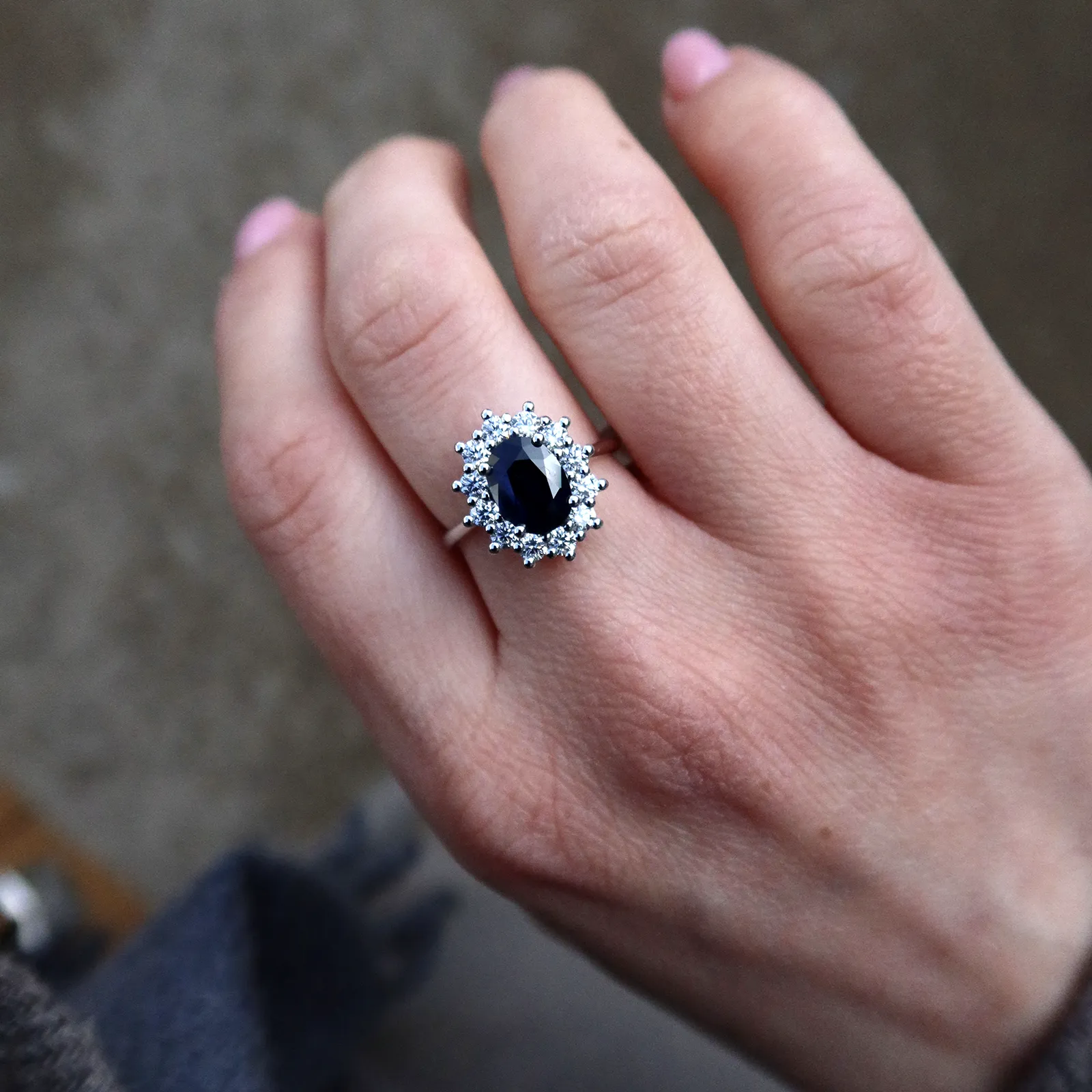 Blue Sapphire Diamond Ring In 18K White Gold With Oval Halo 2 - Orogem Jewelers Sapphire And Diamond Ring Worn On Hand In Natural Light