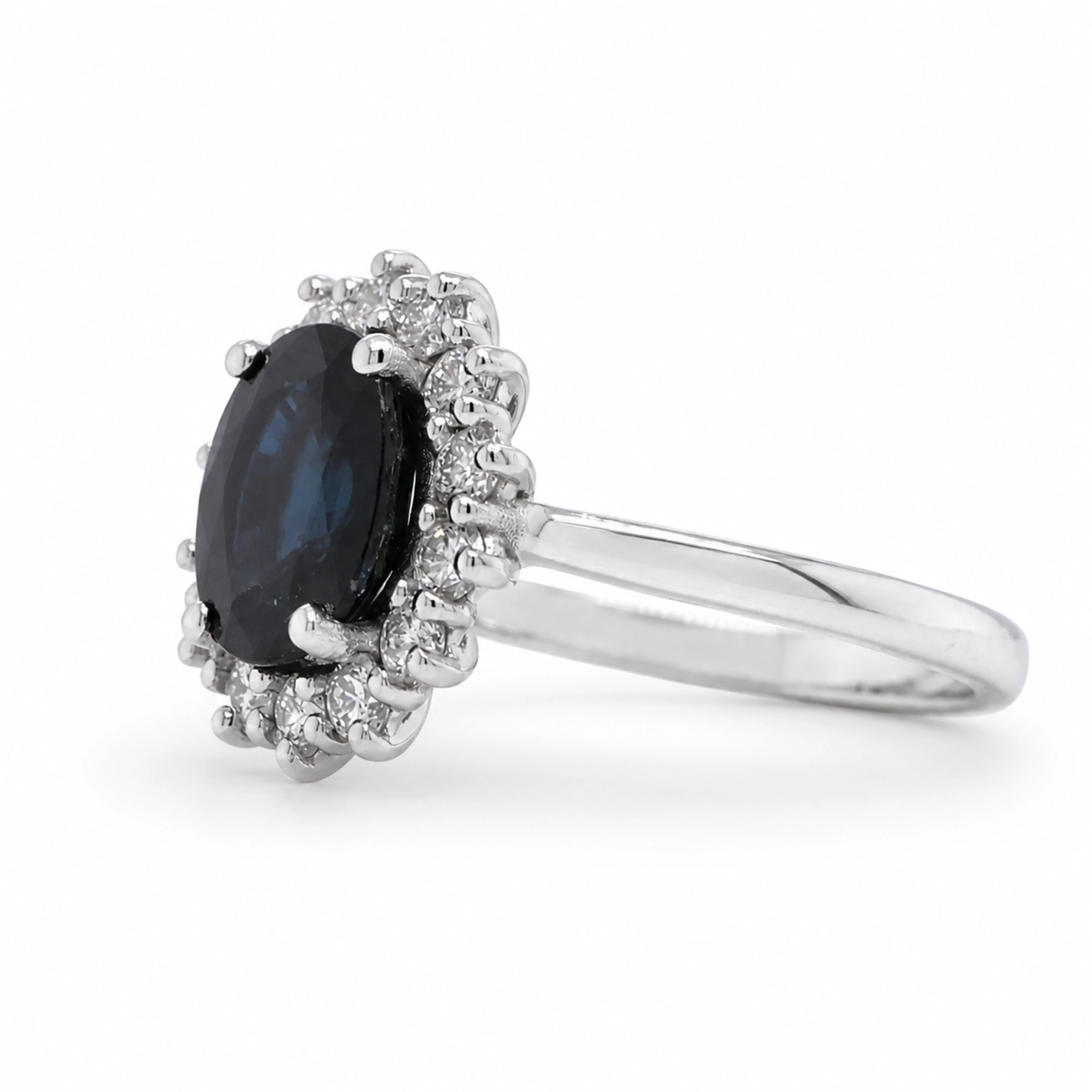 Blue Sapphire Diamond Ring In 18K White Gold With Oval Halo 3 - Orogem Jewelers Side View Of A Blue Sapphire Diamond Ring In 18K White Gold With A 2.19 Ct Oval Sapphire And 0.51 Ct Natural Diamond Halo.