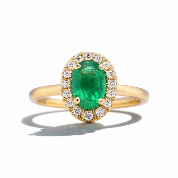 Oval emerald halo ring with natural diamonds in yellow gold on white background