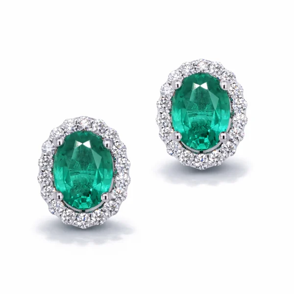 Coppia di orecchini halo con smeraldi ovali 2.56 ct e diamanti 0.52 ct D–F VS in oro bianco 18k.