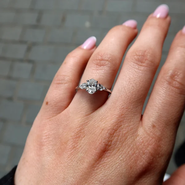 Elegant oval cut diamond trilogy ring in 18K white gold featuring a 0.70 carat F SI1 GIA-certified center diamond, accented by 0.28 carats of natural D–F VS side diamonds for refined brilliance and timeless elegance