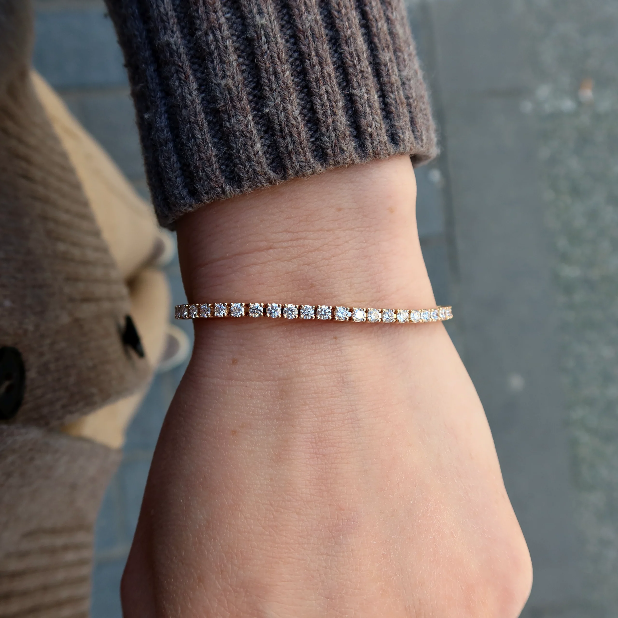 Roségouden Diamanten Tennisarmband 3.54 Ct In 18K Goud Fijn 3 - Orogem Jewelers Bovenaanzicht Van Roségouden Diamanten Tennisarmband Gedragen Om De Pols In 18K Roségoud Met Een Doorlopende Fijne Schittering.
