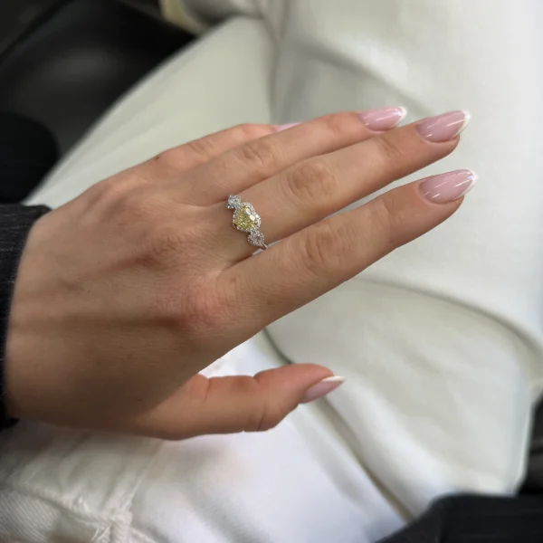 A romantic three-stone engagement ring centred around a 1.01 ct GIA-certified Fancy Light Yellow heart cut diamond, framed by delicate pavé brilliance and complemented by pear cut side diamonds.