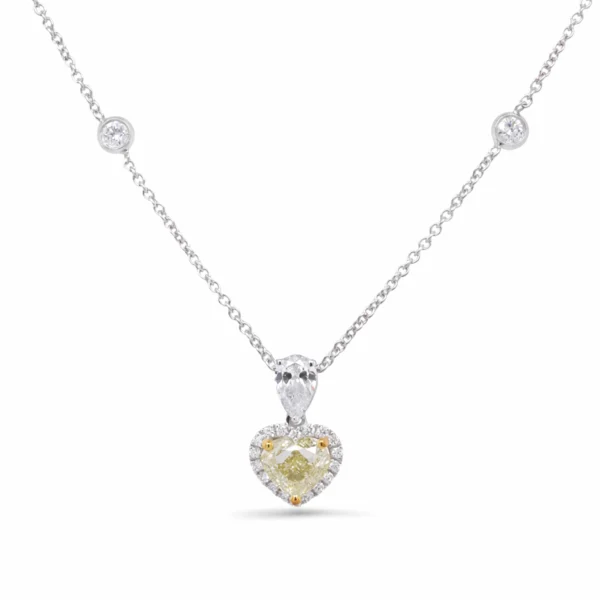 Collana halo con diamante cuore giallo in oro bianco 18k con diamante Fancy Light Yellow taglio cuore certificato GIA da 1,01 ct, accento taglio pera, halo e diamanti sulla catena.