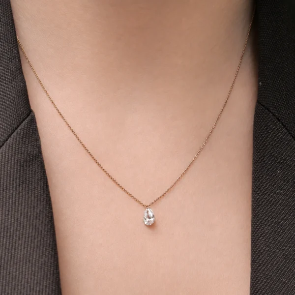 Rose gold pear diamond pendant worn on the neck with a floating 0.50 ct lab grown pear cut diamond.