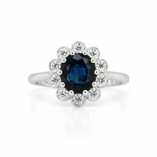 Oval sapphire floral halo ring in 18k white gold with a 1.36 ct blue sapphire and 0.41 ct D-F VS diamonds, front view.