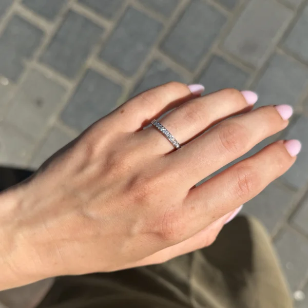 Witgouden diamanten trouwring gedragen aan de hand in 18k met een fijne lijn channel-set D-F VS diamanten.