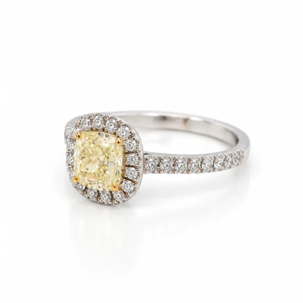 Veduta obliqua del diamante cushion Fancy Light Yellow e del suo halo di diamanti bianchi su gambo in oro bianco