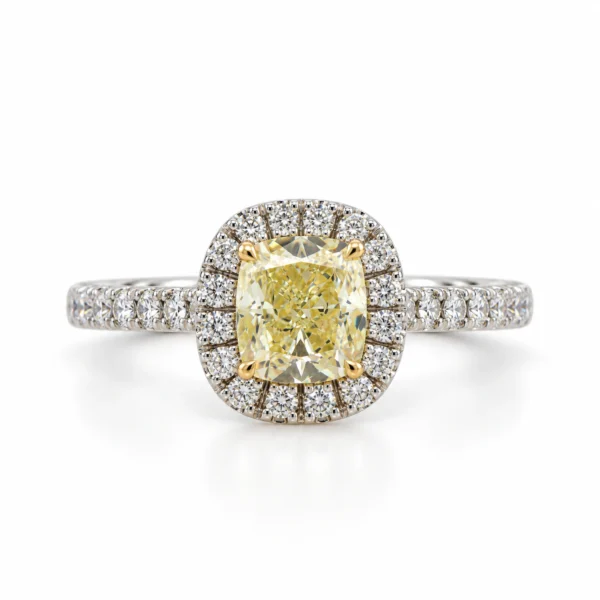 Anello di fidanzamento con diamante cushion Fancy Light Yellow da 0,41 carati in un halo di brillanti rotondi D–F, oro bianco 18 carati, visto di fronte